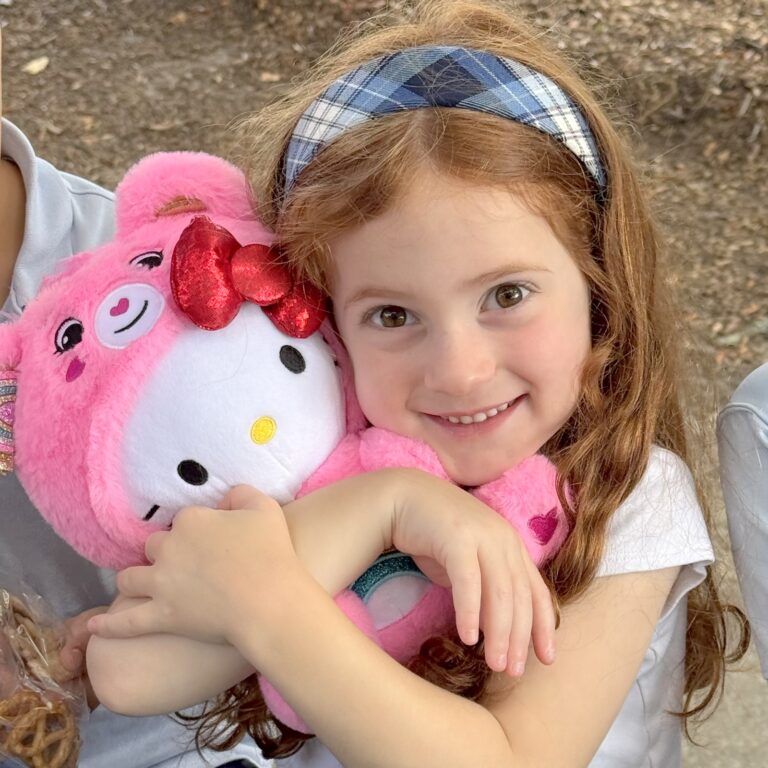 a young student hugging a teddy bear