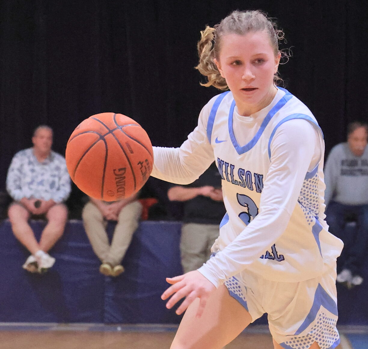 a girls basketball player dribbling during a game