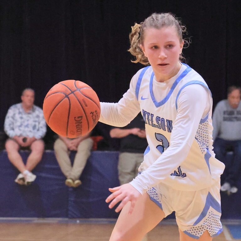 a girls basketball player dribbling during a game