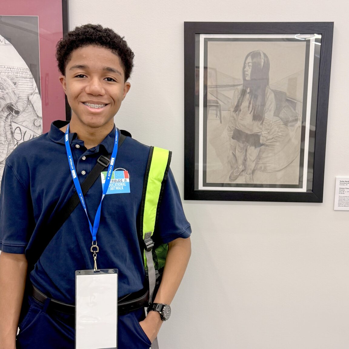 A Wilson Hall Student in front of artwork.